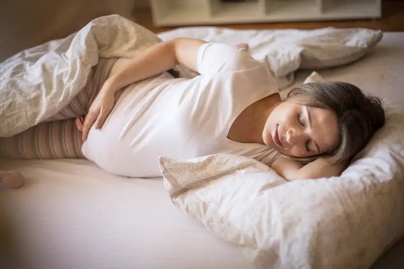 Zwangere vrouw in bed