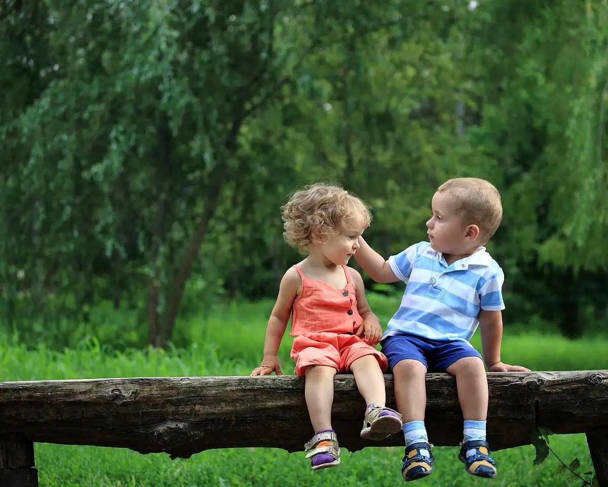 Twee kinderen op een boomstam